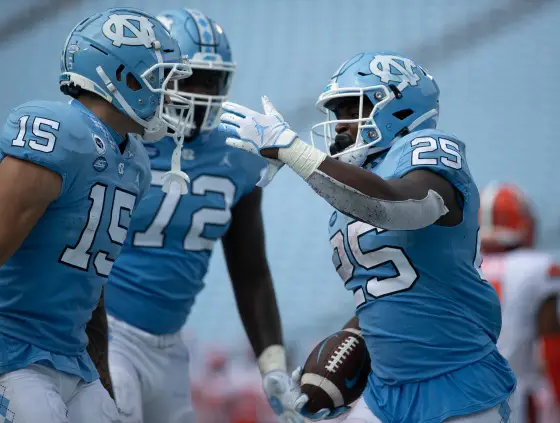 North Carolina's Javonte Williams (25) celebrates with teammates after scoring a touchdown to give the Tar Heels' a 24-6 lead in the fourth quarter against Syracuse on Saturday.