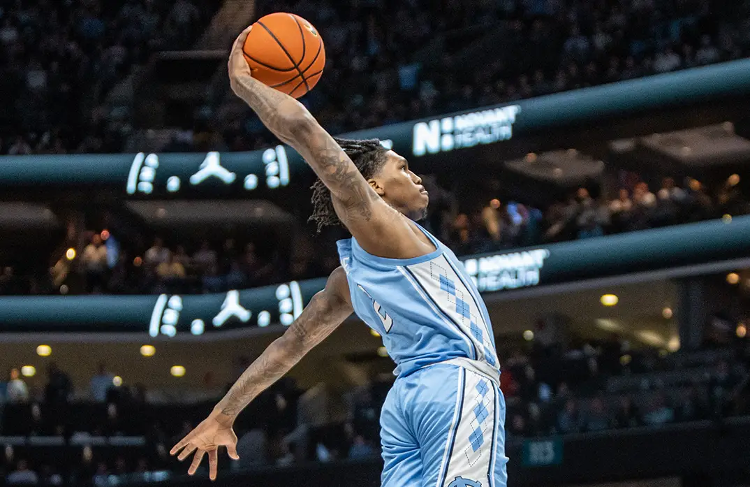 Caleb Love drives for a dunk in UNC's victory over Michigan.